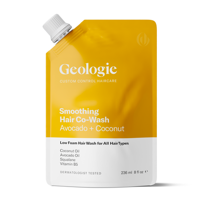 A yellow and white pouch of Geologie Co-Wash Cleansing Conditioner, containing avocado and coconut. The front labels include ingredients, indicate it is low foam and suitable for all hair types, and highlight that it cleans and conditions hair for a healthier scalp.