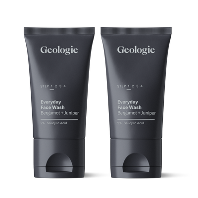 Two tubes of Geologie Salicylic Acid Face Wash with labels for everyday face wash bergamot + juniper and 2% salicylic acid, standing upright on a reflective surface.