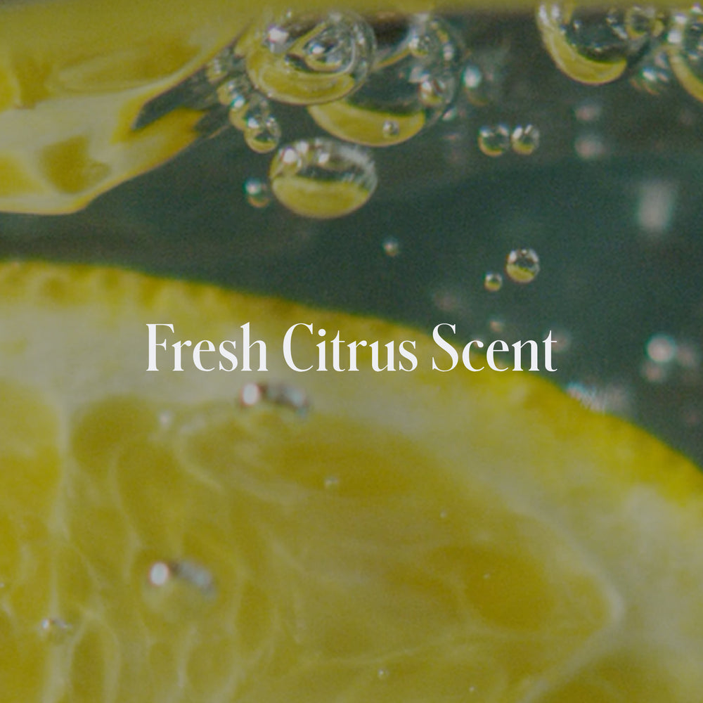 Close-up of lemon slices and bubbles in liquid with the text 'Fresh Citrus Scent' for Geologie's Acne Control Face Wash.