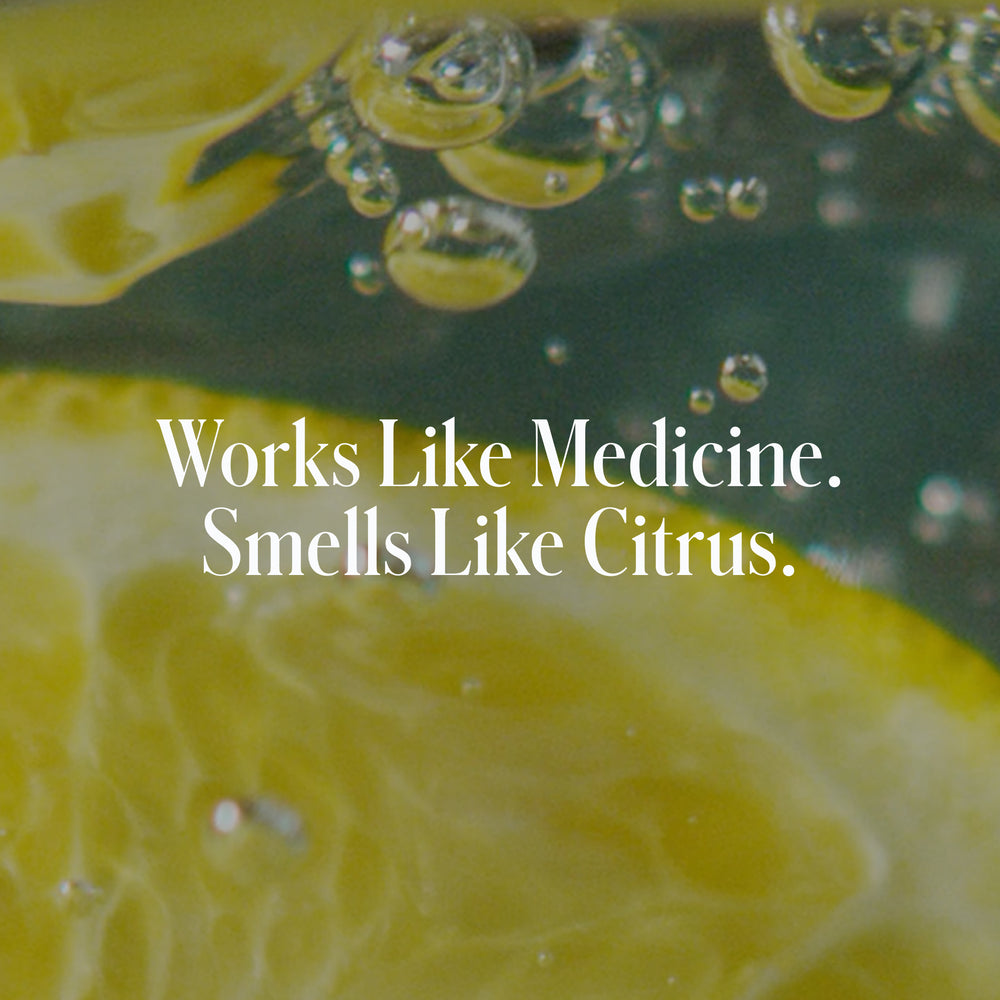 Close-up of lemon slices and bubbles in liquid with 'Works Like Medicine. Smells Like Citrus.' in white font, showcasing the refreshing power of salicylic acid in Geologie's Acne Control Face Wash.
