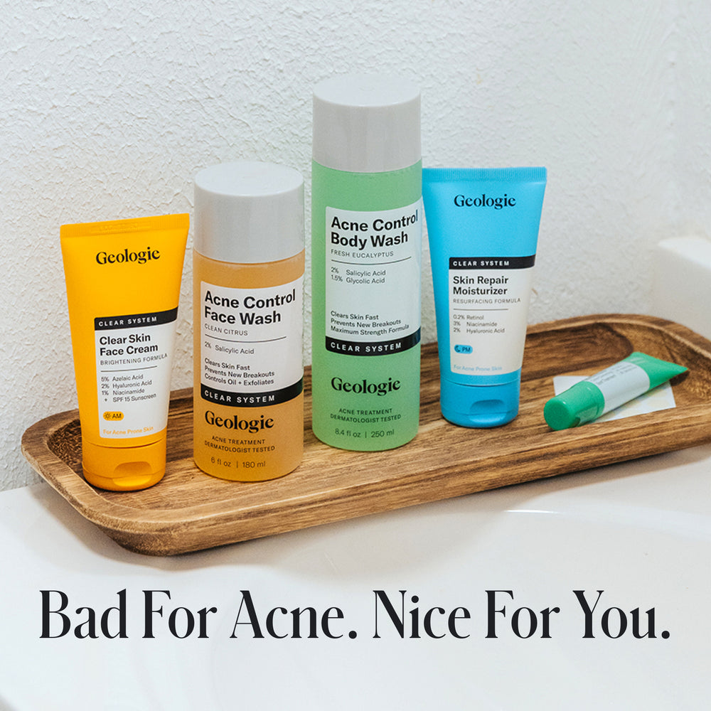 Four Geologie Clear Skin Face Cream products, featuring azelaic acid, are displayed on a wooden tray with the tagline 'Bad For Acne. Nice For You.'—showcasing their Clear Skin Face Cream Acne Treatment System.