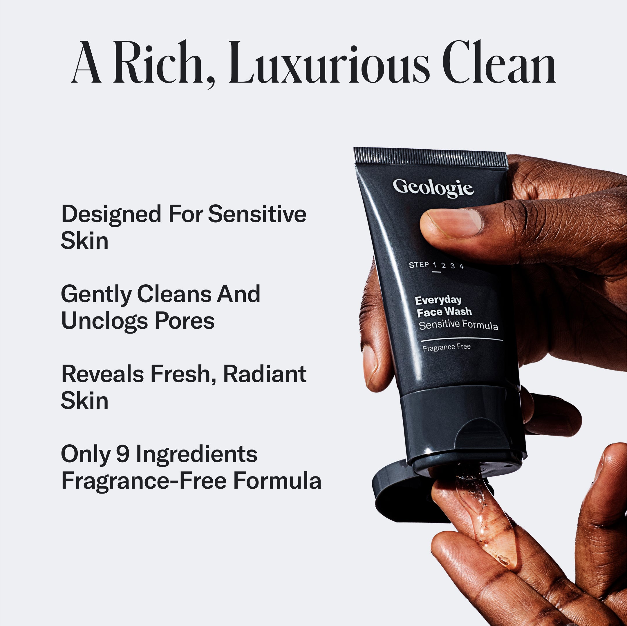 Hand holding a tube of Geologie Sensitive Skincare Set against a dark background with text describing the product as luxurious, enriched with hyaluronic acid, and suitable for sensitive skin.