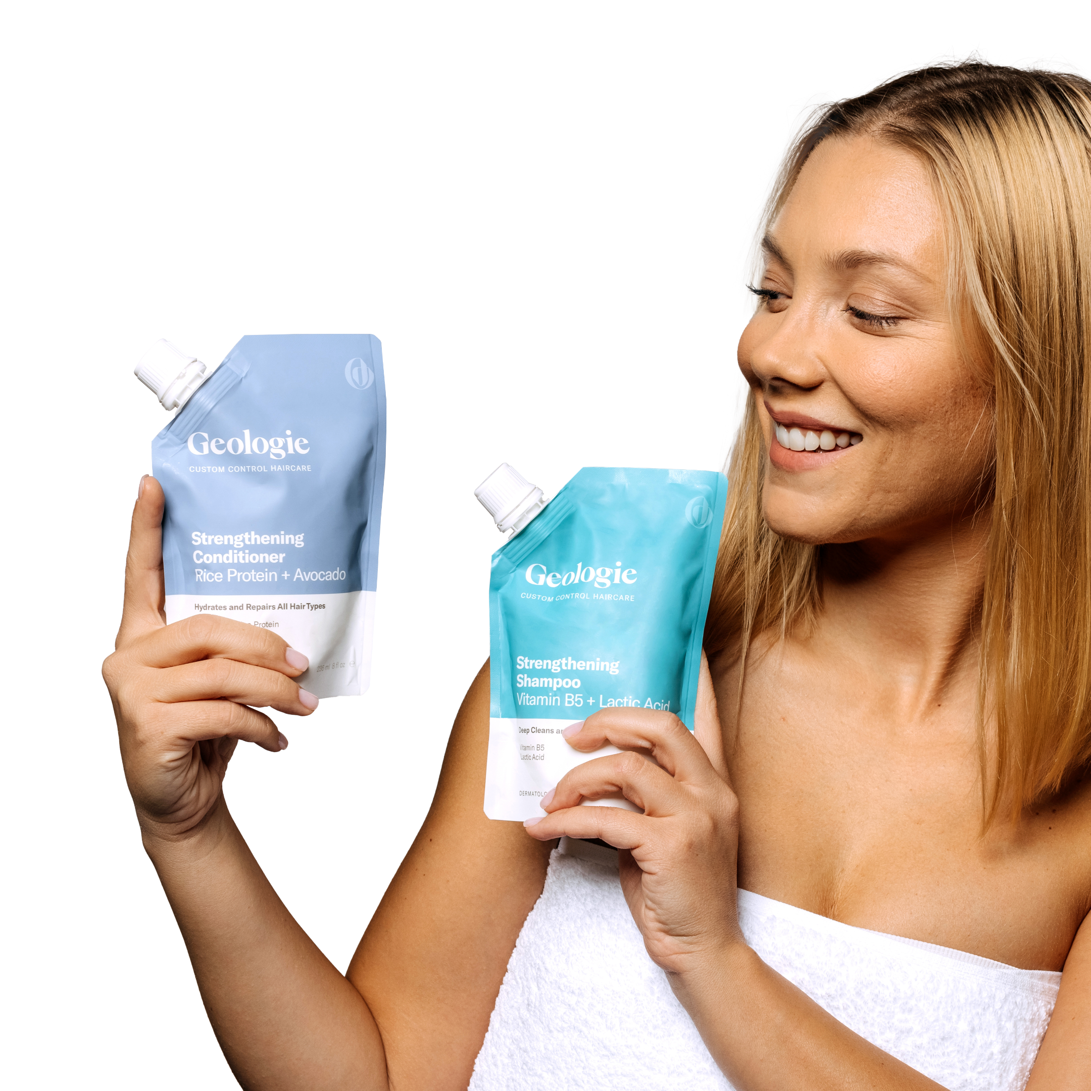 A smiling woman examining two bottles of Geologie Custom Control Hair Routine shampoo and conditioner for hair control.