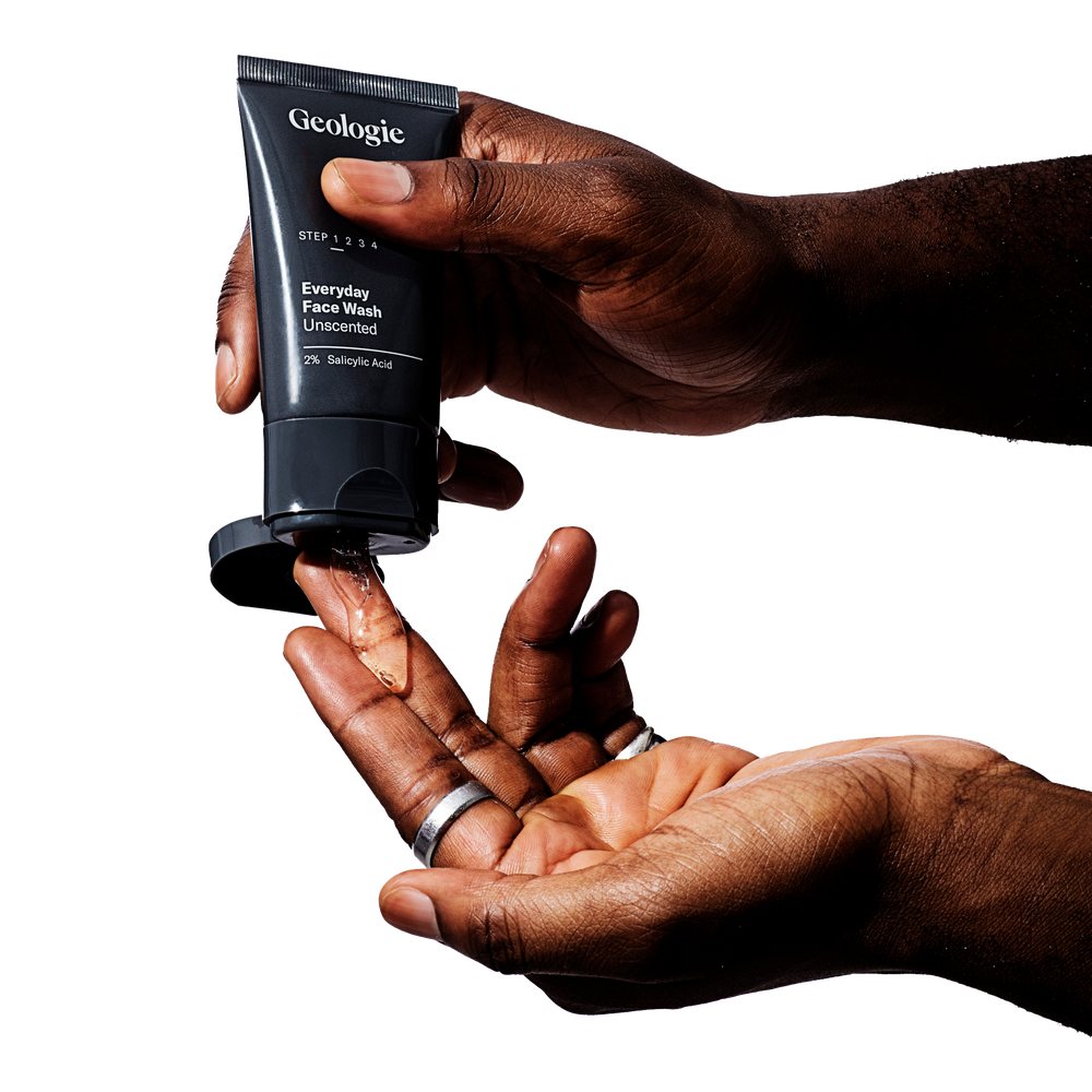A person dispensing Acne Duo gel face wash from Geologie, formulated with effective ingredients, from a tube into their hand.