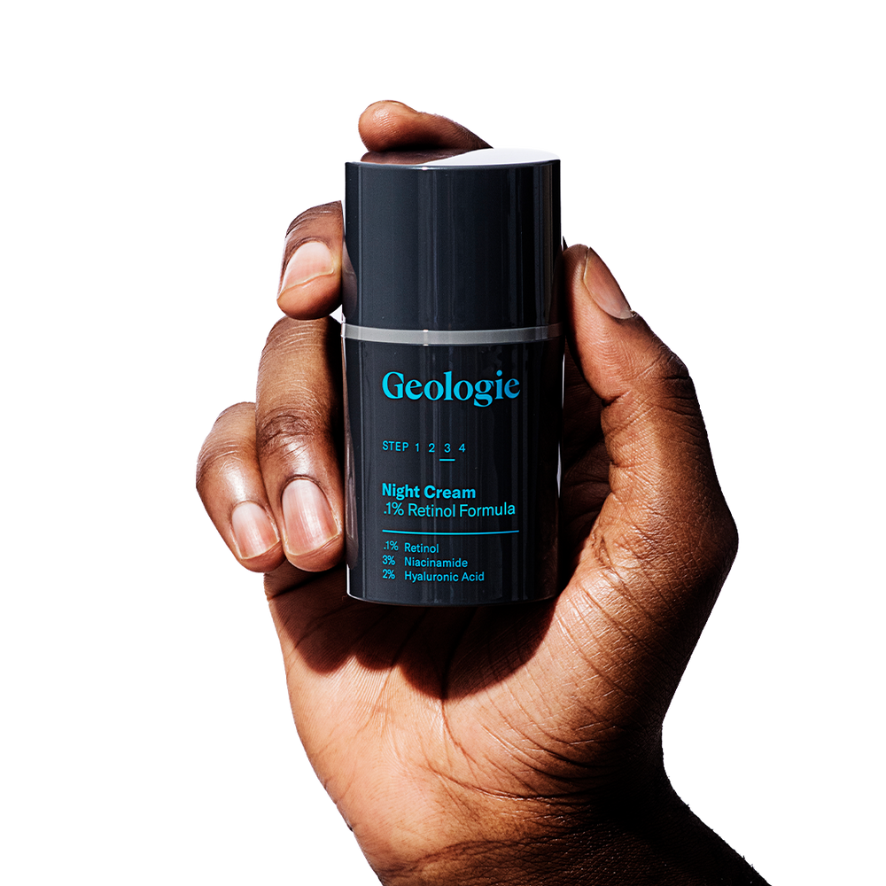 A person holding a bottle of Geologie Acne Duo with a label indicating it contains retinol and hyaluronic acid, designed for an acne regimen.