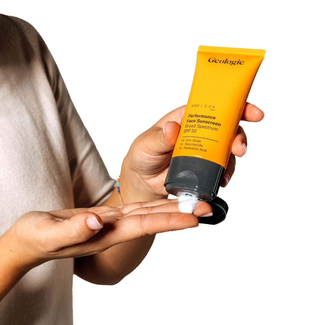 Person holding a yellow tube of Geologie Anti Aging Duo plant-based sunscreen with SPF.